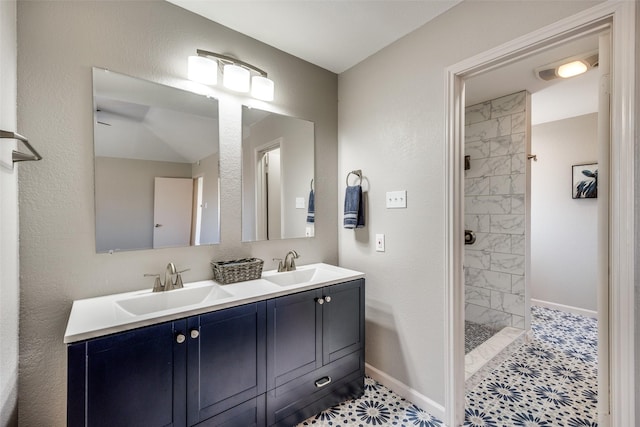 bathroom featuring a tile shower, vanity, and tile patterned floors