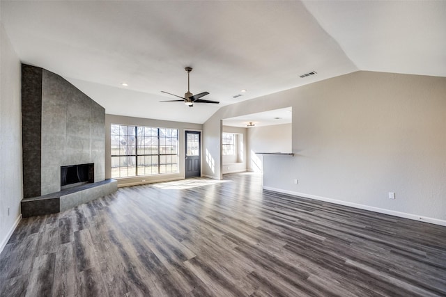 unfurnished living room with ceiling fan, lofted ceiling, a fireplace, and dark wood-type flooring