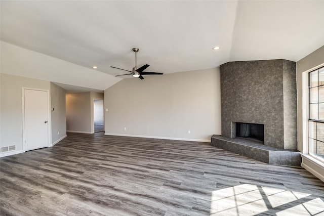 unfurnished living room with hardwood / wood-style floors, ceiling fan, lofted ceiling, and a tiled fireplace