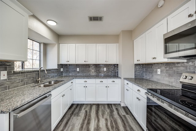 kitchen with dark wood-type flooring, sink, light stone counters, white cabinetry, and stainless steel appliances