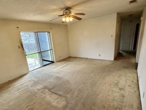 unfurnished room with ceiling fan, carpet, and a textured ceiling