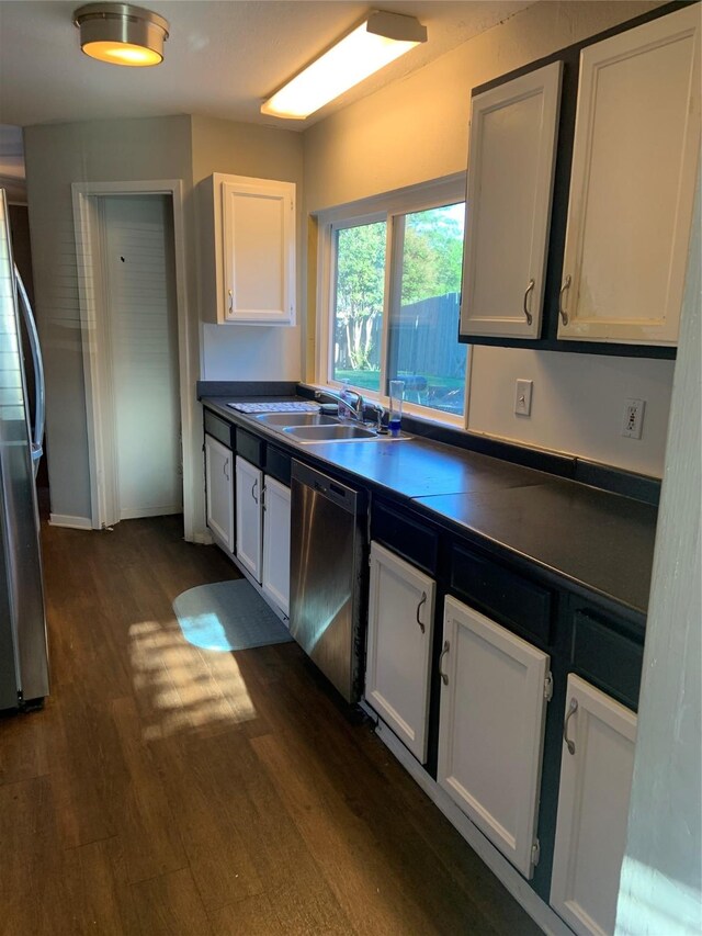 kitchen featuring white cabinets, appliances with stainless steel finishes, dark hardwood / wood-style floors, and sink