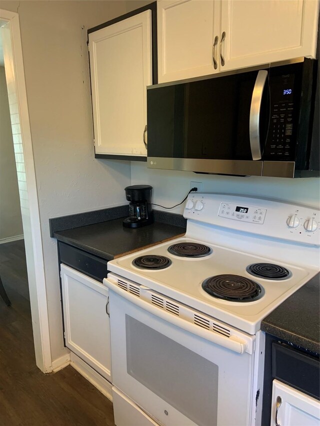 kitchen with white cabinets, electric range, and dark hardwood / wood-style floors