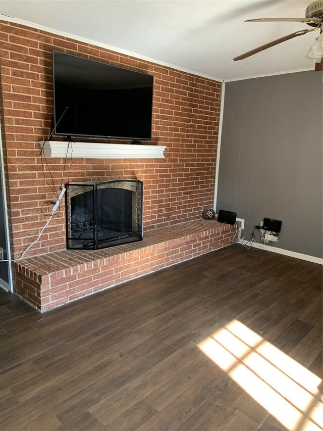 unfurnished living room with ceiling fan, dark hardwood / wood-style floors, and a brick fireplace