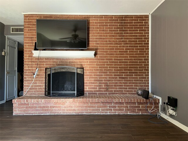 interior details featuring ceiling fan, wood-type flooring, and a brick fireplace