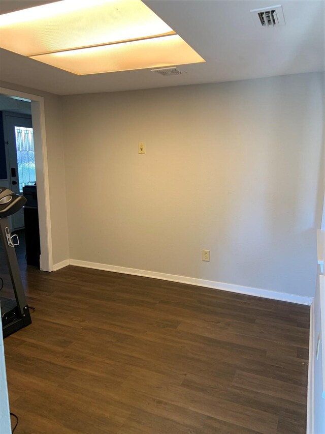 unfurnished room with dark wood-type flooring