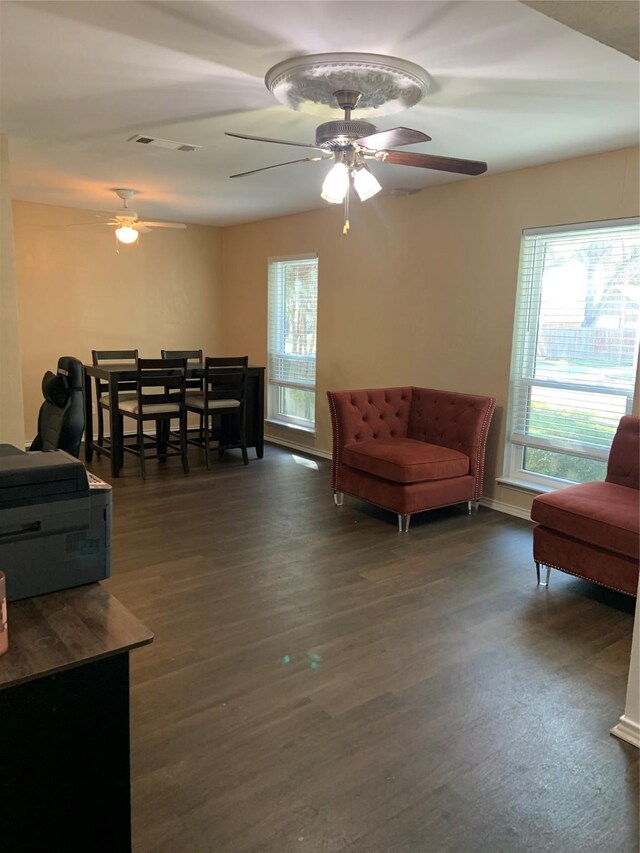 living room featuring ceiling fan and dark hardwood / wood-style flooring