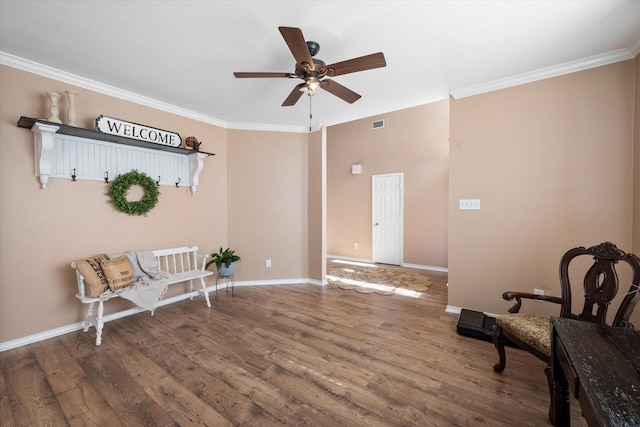 sitting room with ceiling fan, wood-type flooring, and ornamental molding