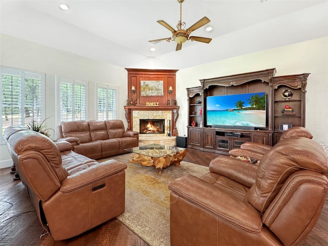 living room featuring a fireplace, vaulted ceiling, ceiling fan, and dark wood-type flooring