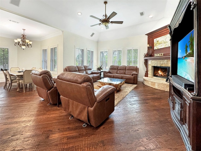 living room with a stone fireplace, crown molding, dark hardwood / wood-style floors, and ceiling fan with notable chandelier