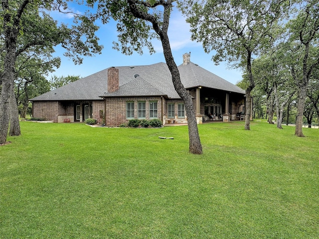 rear view of property with a yard