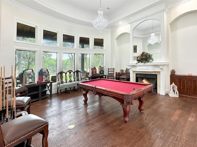 recreation room with dark hardwood / wood-style flooring, ornamental molding, an inviting chandelier, a fireplace, and pool table