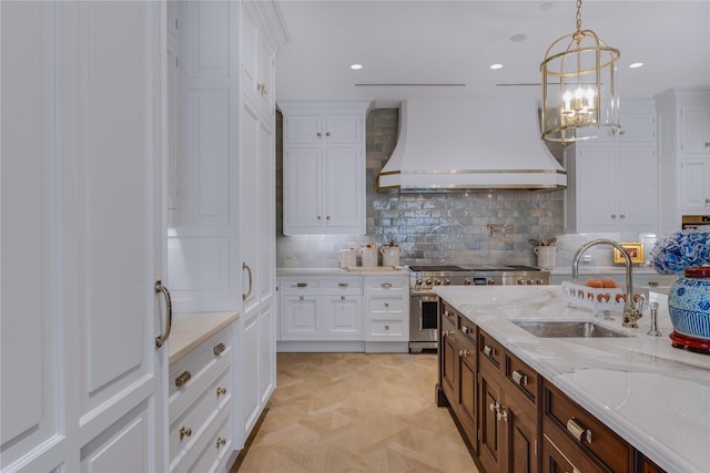 kitchen featuring sink, stainless steel stove, white cabinetry, custom range hood, and light parquet flooring