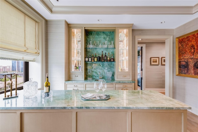 bar with light stone counters and ornamental molding