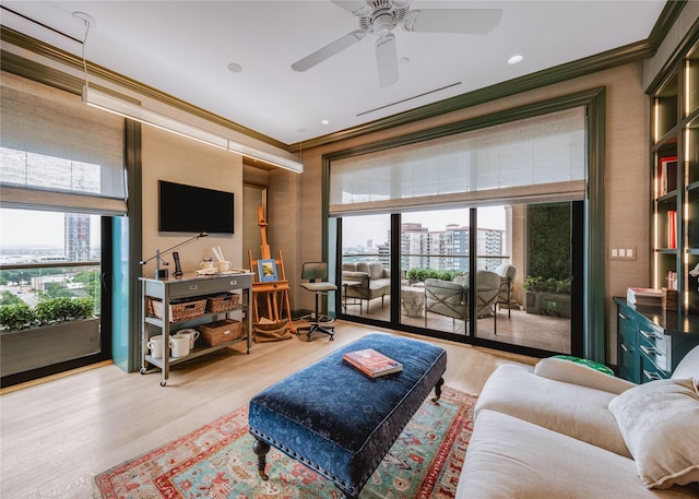 living room with crown molding, ceiling fan, and light hardwood / wood-style flooring