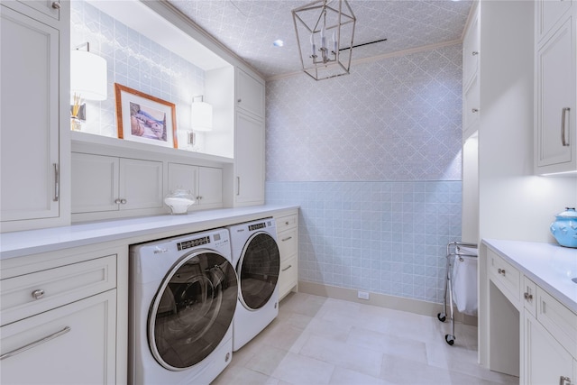 washroom with tile walls, washer and clothes dryer, and cabinets