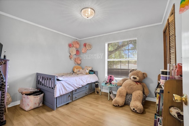 bedroom with ornamental molding and light hardwood / wood-style floors