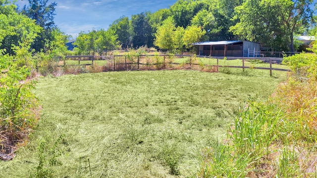 view of yard featuring an outdoor structure and a rural view