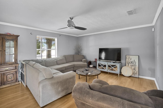 living room with crown molding, ceiling fan, and light wood-type flooring