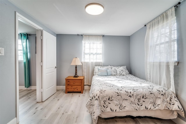 bedroom with light hardwood / wood-style flooring and multiple windows