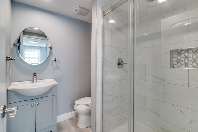 bathroom with toilet, vanity, a shower with door, and hardwood / wood-style flooring