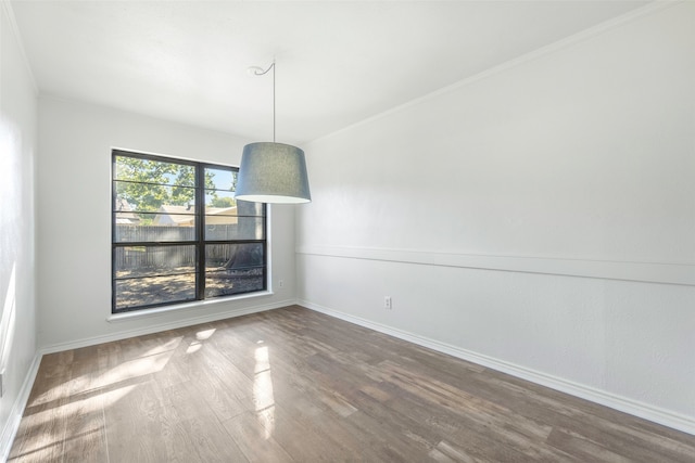 unfurnished room with hardwood / wood-style floors and crown molding