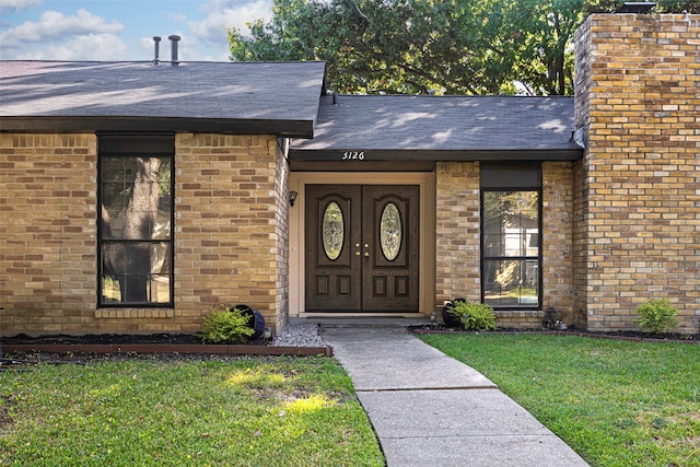 property entrance with a lawn