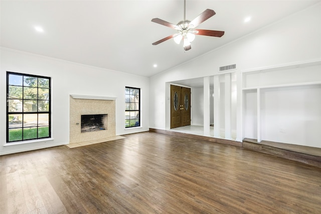 unfurnished living room with lofted ceiling, crown molding, ceiling fan, dark hardwood / wood-style flooring, and a tiled fireplace