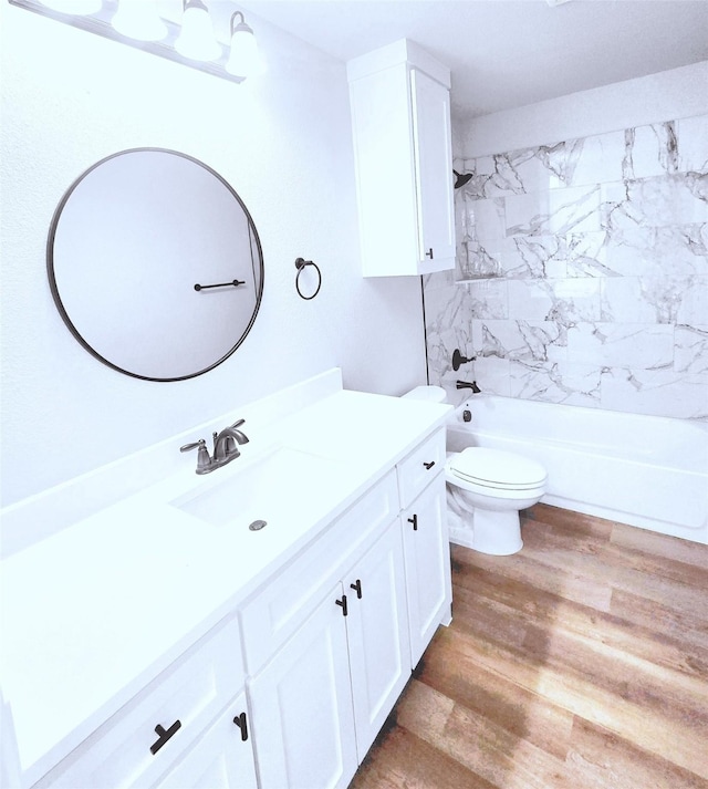 full bathroom featuring hardwood / wood-style flooring, toilet, vanity, and tiled shower / bath