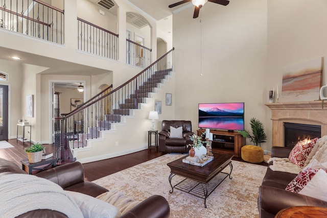 10014 Edgeway Cir, Rowlett, TX 75089 - living room featuring a ceiling fan, a towering ceiling, stairs, and wood finished floors