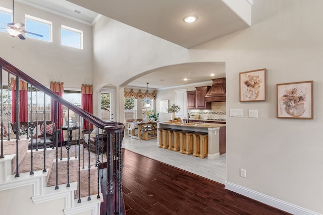 10014 Edgeway Cir, Rowlett, TX 75089 - stairs with arched walkways, crown molding, a ceiling fan, wood finished floors, and baseboards