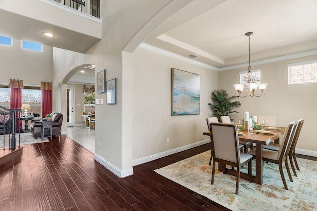 10014 Edgeway Cir, Rowlett, TX 75089 - dining area with arched walkways, baseboards, wood finished floors, a chandelier, and a raised ceiling