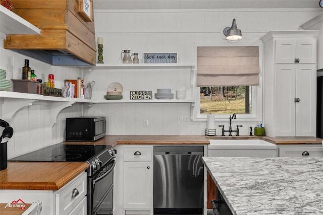 kitchen featuring white cabinets, appliances with stainless steel finishes, light stone countertops, and sink