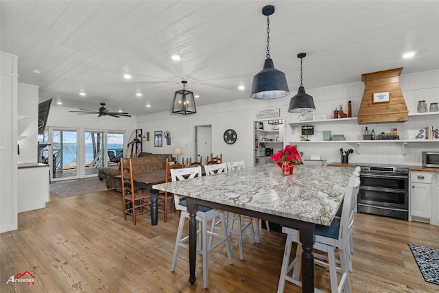 dining room with ceiling fan and light wood-type flooring