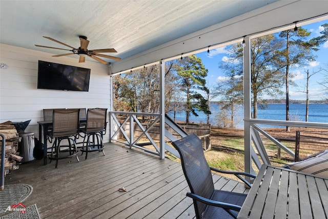 deck with ceiling fan and a water view