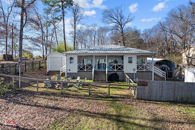 back of house with a porch and an outbuilding