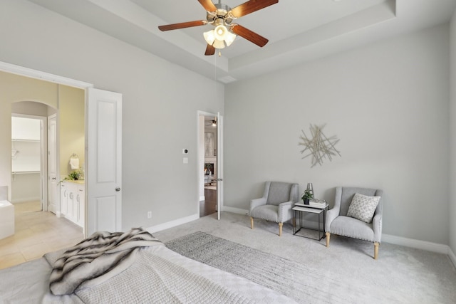 carpeted bedroom featuring a raised ceiling and ceiling fan