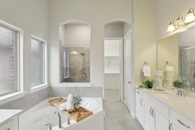 bathroom featuring vanity, plus walk in shower, and tile patterned flooring