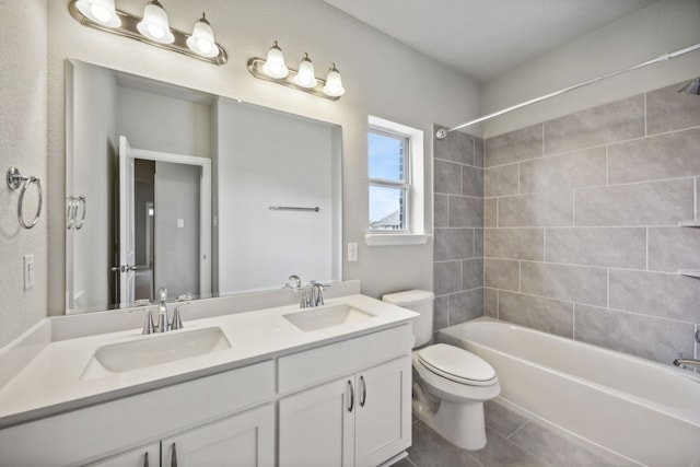 full bathroom with tiled shower / bath combo, vanity, tile patterned flooring, and toilet