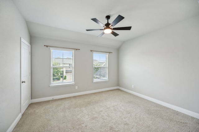 spare room featuring vaulted ceiling, ceiling fan, and carpet