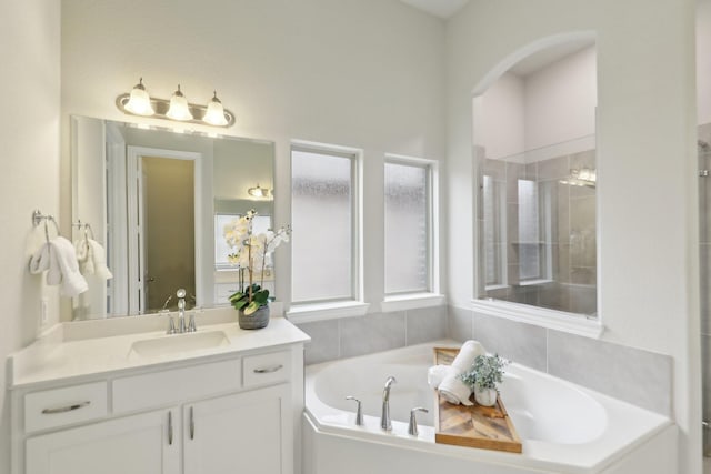 bathroom with vanity and shower with separate bathtub