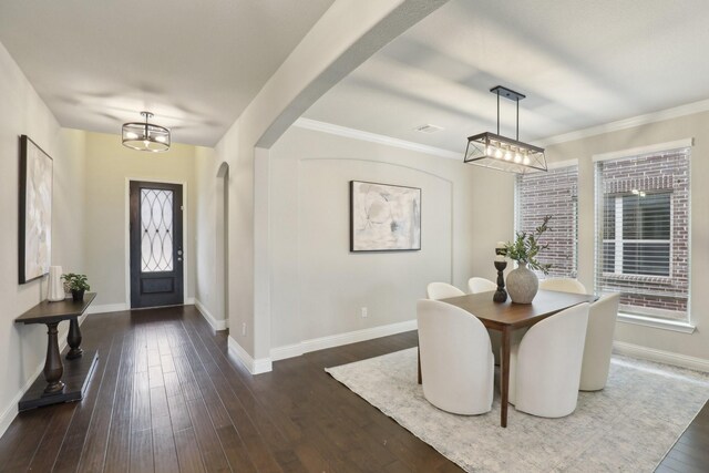 dining room featuring crown molding, dark hardwood / wood-style flooring, and a notable chandelier