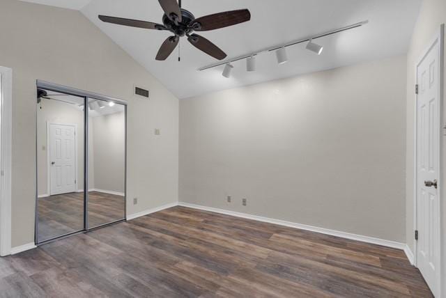 unfurnished bedroom featuring a closet, dark hardwood / wood-style floors, ceiling fan, and rail lighting