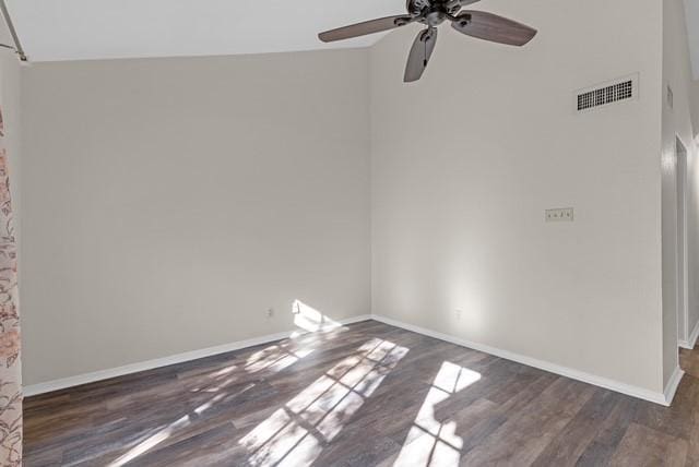 empty room with dark hardwood / wood-style floors, ceiling fan, and vaulted ceiling