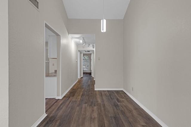 corridor with dark hardwood / wood-style flooring