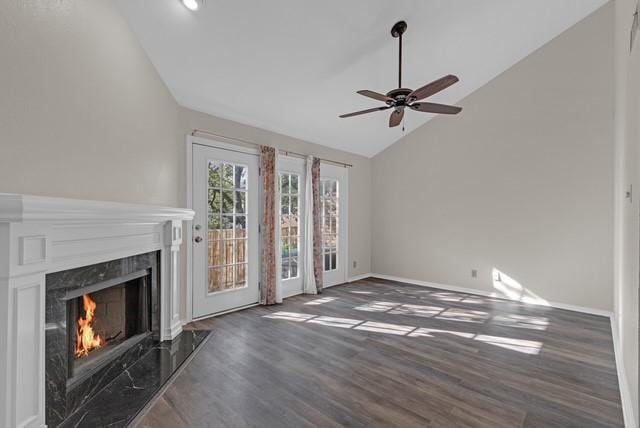 unfurnished living room featuring a fireplace, dark hardwood / wood-style flooring, ceiling fan, and lofted ceiling