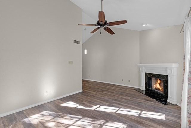 unfurnished living room with hardwood / wood-style floors, ceiling fan, a fireplace, and vaulted ceiling