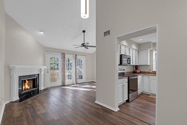 kitchen featuring dark hardwood / wood-style flooring, a fireplace, ceiling fan, electric range, and white cabinets