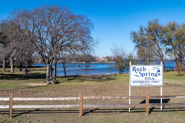 surrounding community with a yard and a water view