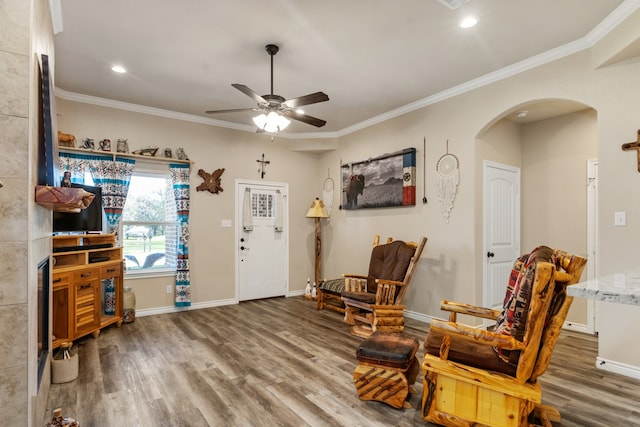 living area featuring ceiling fan, dark hardwood / wood-style floors, and crown molding